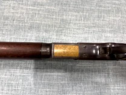 Winchester Model 1873 receiver underside and brass cartridge carrier marked 44 CAL